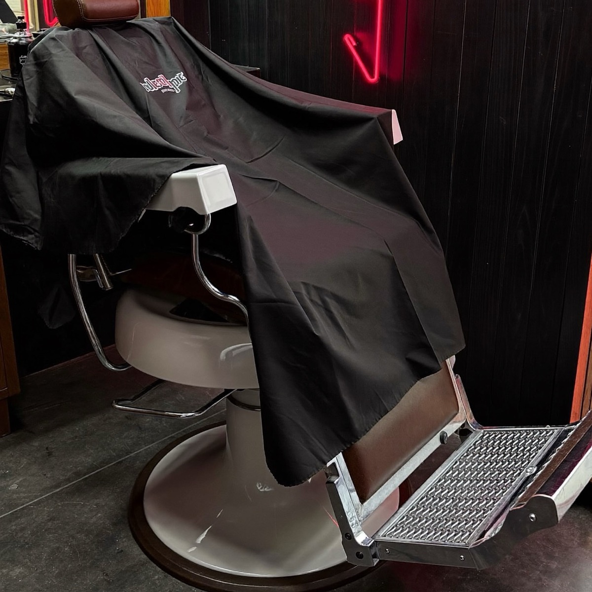 Barber cape draped over a leather chair