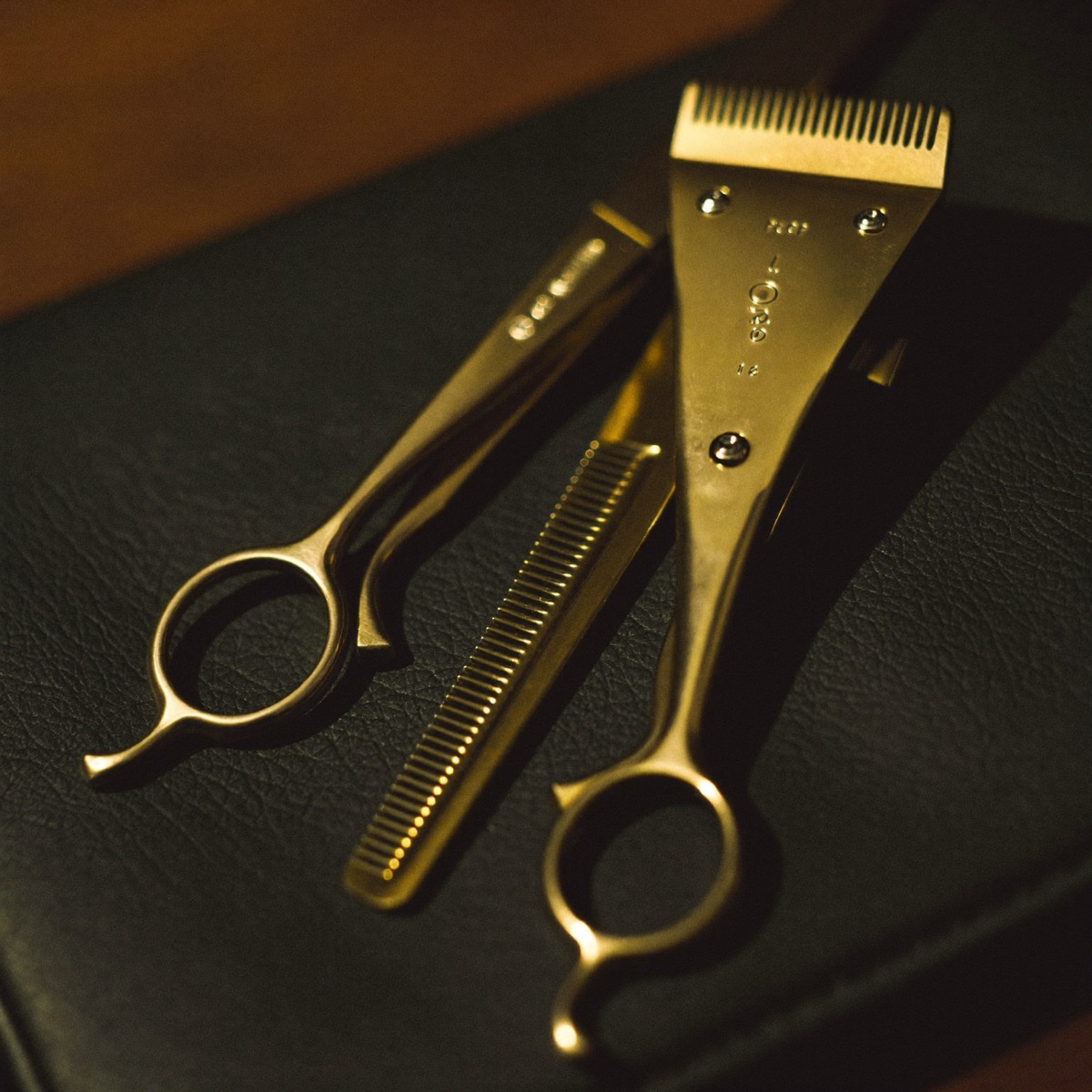 Gold clippers on a leather barber station