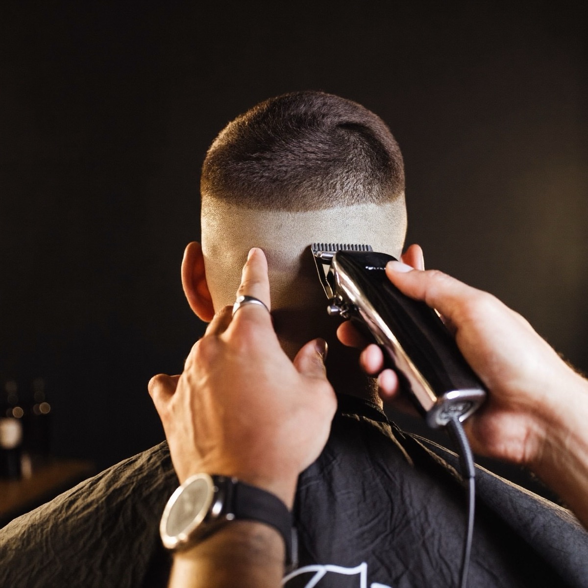 Barber trimming a clean fade with clippers